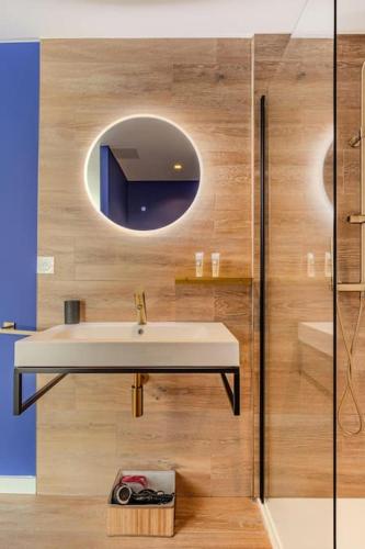 une salle de bain avec un lavabo et un miroir dans l'établissement Cocon Noely 2, à Toulouse