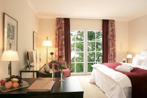 a bedroom with a bed and a large window at Naturresort & Spa Schindelbruch in Stolberg i. Harz