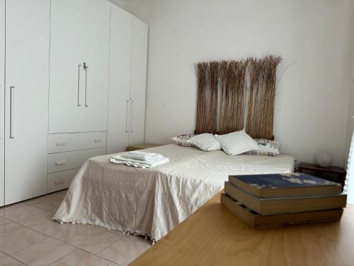 um quarto branco com uma cama e uma mala no chão em Peschici a due passi em Peschici