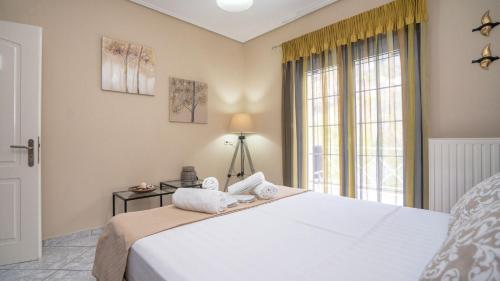 a bedroom with a large white bed with a window at Boutique St Stephens Residence in Kalabaka