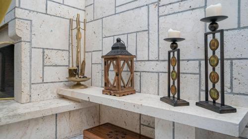 a shelf with candles and lanterns on a brick wall at Boutique St Stephens Residence in Kalabaka