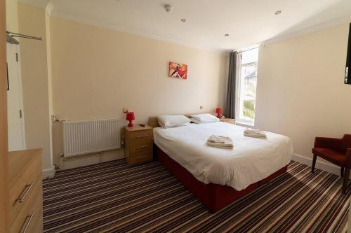 Een bed of bedden in een kamer bij Bournemouth Sands Hotel