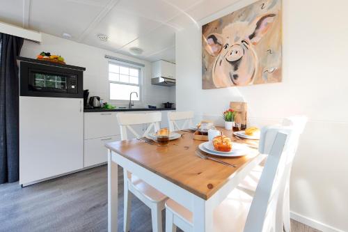 a kitchen and dining room with a wooden table and chairs at 73, ponds - Kampina - Cycling - Airco - Tranquil! - Recreational Only in Oisterwijk