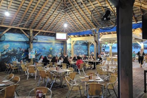 people sitting at tables in a restaurant with a mural at 6 BR Beach view -Sleeps 14 -Rolling with the flow in Galveston