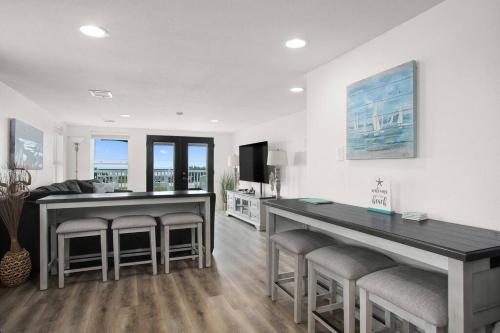 a kitchen with two tables and stools in a room at 6 BR Beach view -Sleeps 14 -Rolling with the flow in Galveston