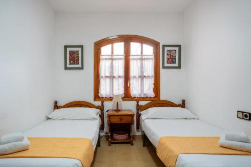 ラメトリャ・デ・マールにあるDúplex con encantoのツインベッド2台と窓が備わる客室です。