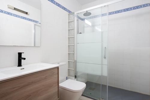 ラメトリャ・デ・マールにあるDúplex con encantoのバスルーム(トイレ、ガラス張りのシャワー付)