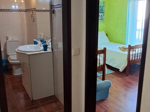 a bathroom with a sink and a room with a bed at Casa Jasmim - charming houses - Alojamento Local - perto Zambujeira do Mar in São Teotónio