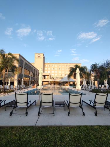 a group of chairs sitting in front of a pool at Gran Amérian Carlos V in Termas de Río Hondo
