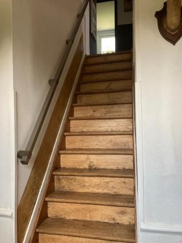 a staircase in a house with wooden floors at Maison et son jardin situés dans le Condroz in Marchin