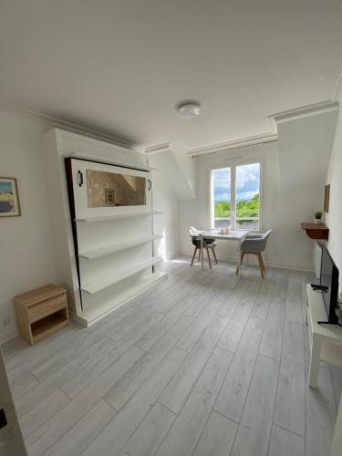 un salon avec une table et un bureau dans l'établissement Studio entièrement refait à neuf, à Bagnoles-de-l'Orne