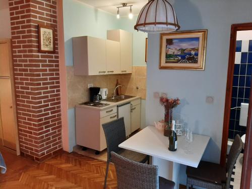 eine kleine Küche mit einem weißen Tisch, einem weißen Tisch und einem Tisch in der Unterkunft Apartments Marija in Murine
