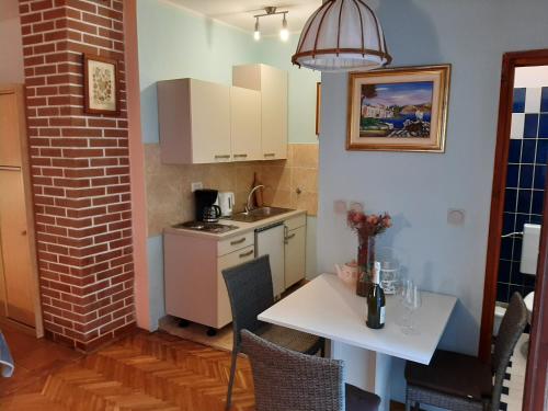 a small kitchen with a white table and a white table and a tableablish at Apartments Marija in Murine