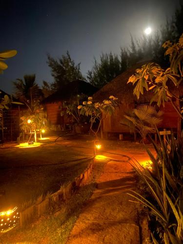 a house with lights in front of it at night at Caju Bangalôs in Ponta do Anel