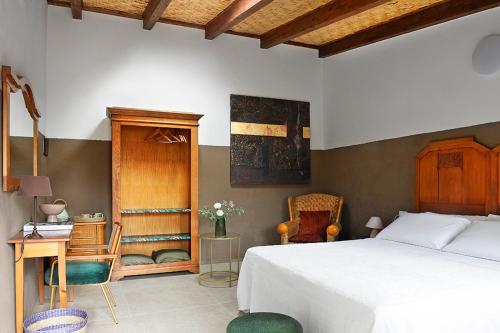 a bedroom with a bed and a desk and chairs at Casa Mediterranea in Nurachi