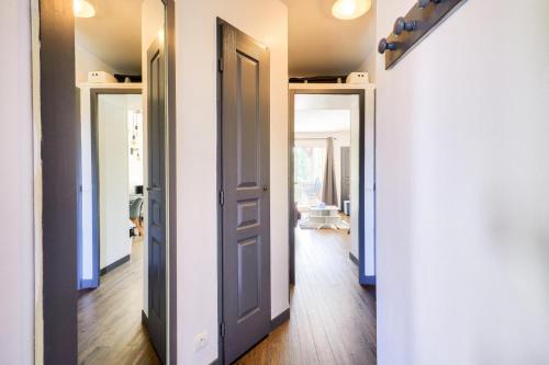 un couloir avec trois portes et un couloir avec parquet dans l'établissement La Résidence du Golf - maeva Home - Appartement 2 pièces 4 personnes - Sélection MAE-6581, à Deauville
