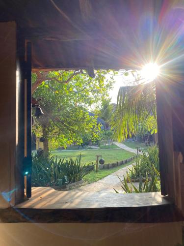a window view of a garden from a house at Caju Bangalôs in Ponta do Anel