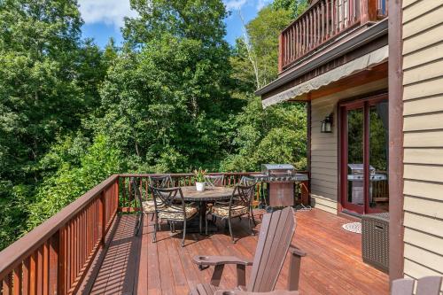 a deck with a grill and a table and chairs at Haven at Headwaters in Elk Park