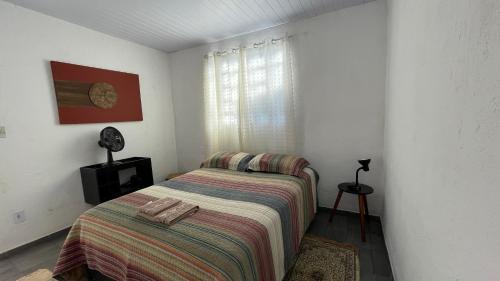 a bedroom with a bed with a striped blanket at Loft Sousas in Campinas
