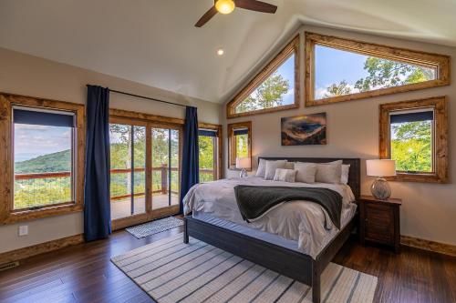 Un dormitorio con una cama grande en una habitación con ventanas. en Blue Heaven, en Blowing Rock