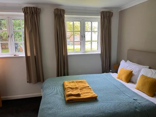 a bedroom with a bed with two towels on it at Green Cottage in grounds of Grade II* Frognal Farmhouse in Sittingbourne