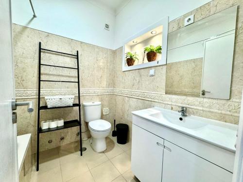 Almada big flat next To Lisbon and Caparica beach في ألمادا: حمام مع مرحاض ومغسلة ومرآة