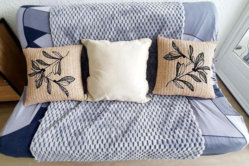 - un lit avec des oreillers dans l'établissement Studio rêve de mer 25 m2, centre ville, parking, cosy neuf, à La Grande Motte