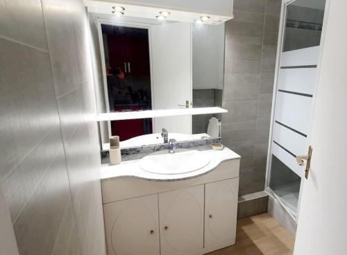 une salle de bain avec un lavabo et un miroir dans l'établissement Studio rêve de mer 25 m2, centre ville, parking, cosy neuf, à La Grande Motte