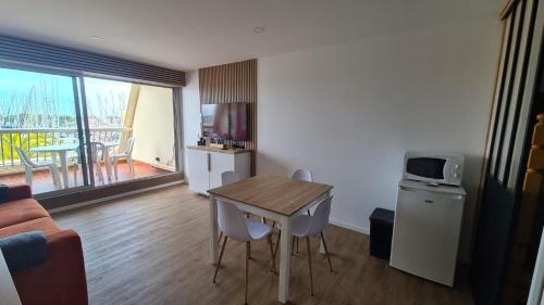 - un petit salon avec une table et un four micro-ondes dans l'établissement super appartement vue port Camargue- Le Grau Du Roi, au Grau-du-Roi