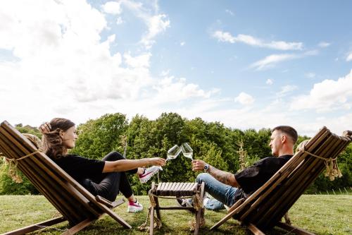 two people sitting in rocking chairs in the grass at Zelena Oaza - B&B in Miklavž pri Ormožu