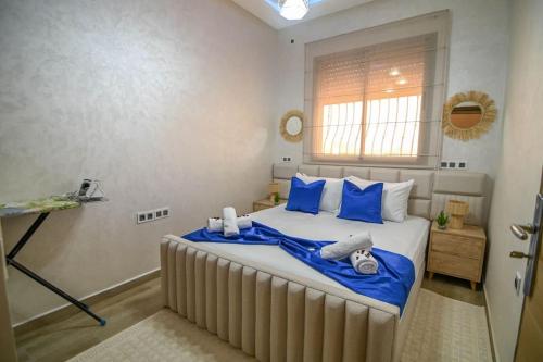 a bedroom with a large bed with blue pillows at The Skyline Stay in Marrakech