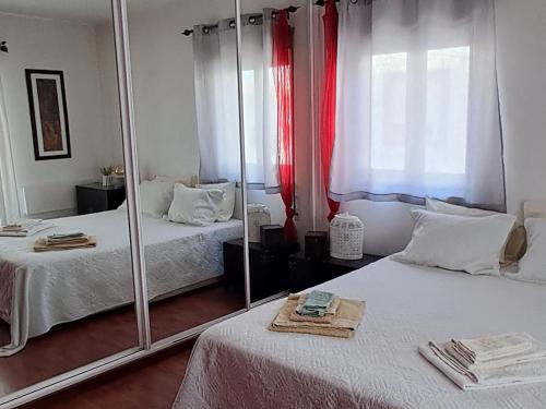 a bedroom with two beds and a mirror at Casa Jasmim - charming houses - Alojamento Local - perto Zambujeira do Mar in São Teotónio