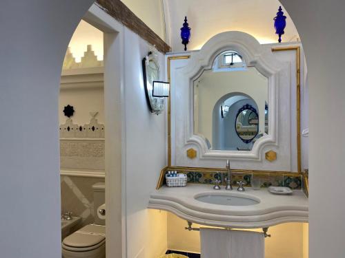 uma casa de banho com um lavatório e um espelho em Positano Suite em Positano