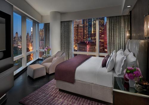um quarto com uma cama grande e uma janela grande em Mandarin Oriental, New York em Nova Iorque