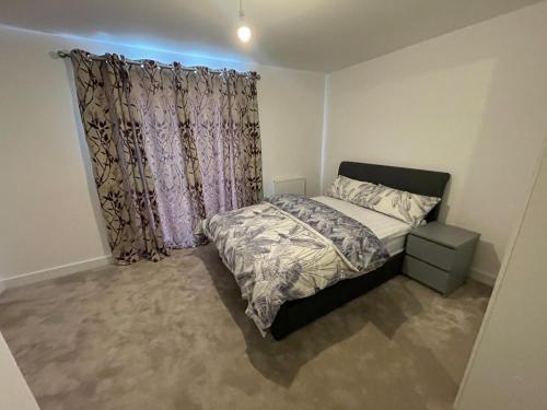 a small bedroom with a bed and a window at Home in Greenhithe in Kent
