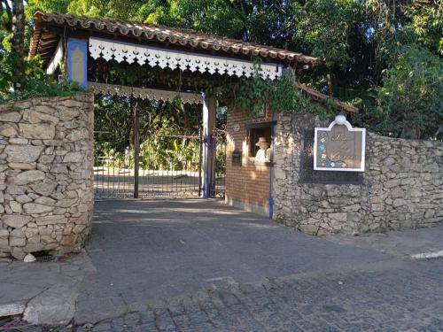 een poort naar een stenen gebouw met een bord erop bij Pouso das Gerais in Tiradentes