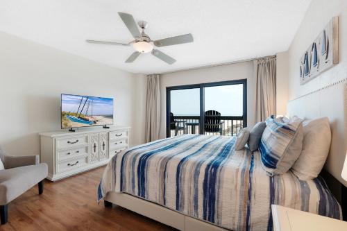 Sunrise beach views with top complex amenities and pool access! في شاطئ أورموند: غرفة نوم بسرير ومروحة سقف