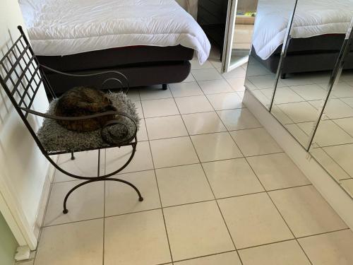 a cat sitting in a chair next to a bed at Droit au but!! in Marseille