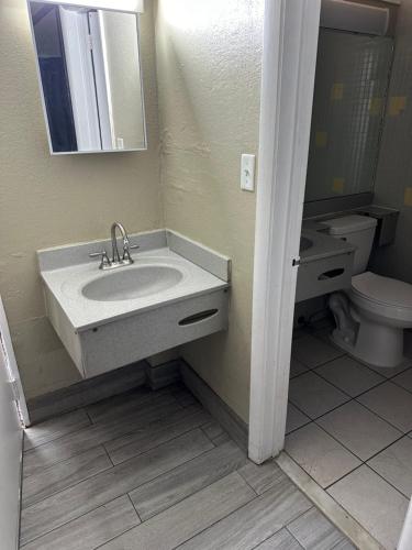 a bathroom with a sink and a toilet at Bravo Inn Greensboro in Greensboro