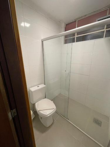 a bathroom with a toilet and a glass shower at Hotel Fazenda Santa Monica in Louveira