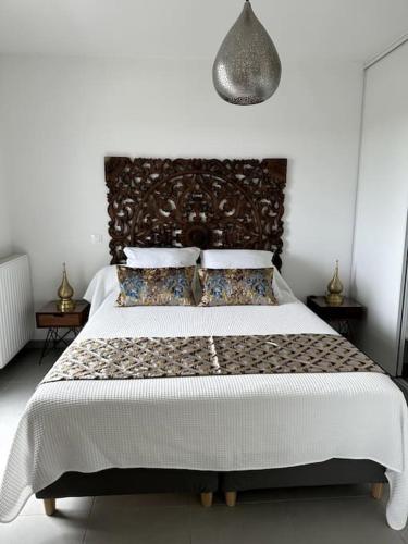 - une chambre dotée d'un grand lit avec une tête de lit et des oreillers dans l'établissement Appart La Mantilla, wifi, clim, parking, Netflix, à Montpellier