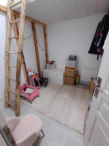 une pièce avec une échelle et une chaise rose dans l'établissement Maison au calme, à Andernos-les-Bains