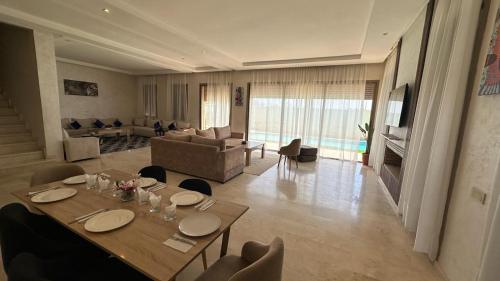 a dining room with a table and a living room at Marrakech in Marrakech
