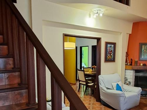 a living room with a staircase and a dining room at Casa Jasmim - charming houses - Alojamento Local - perto Zambujeira do Mar in São Teotónio