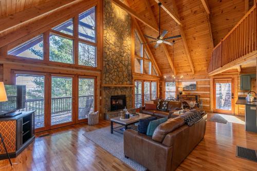 Una sala de estar con un sofá y una chimenea. en Happy Trees Cabin, en Laxon