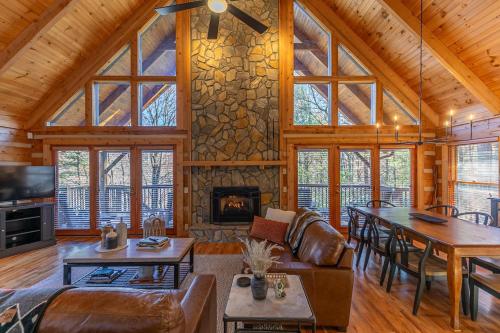 Una sala de estar con chimenea en una cabaña de troncos en Happy Trees Cabin, en Laxon