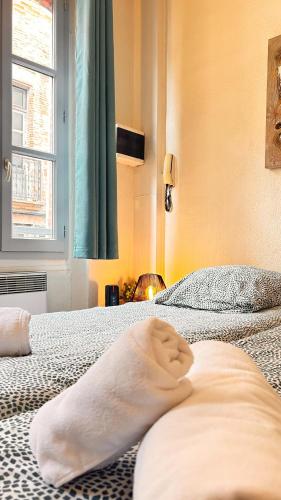 une chambre avec deux lits avec des serviettes dessus dans l'établissement L'abri douillet, à Montauban