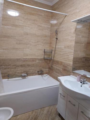 a bathroom with a tub and a toilet and a sink at TSG Apartaments in Valea lui Mihai