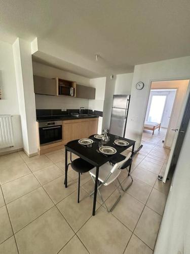 une cuisine avec une table et des chaises dans une pièce dans l'établissement T3 proche Montpellier centre, à Montpellier