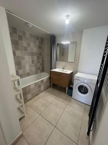 une salle de bain avec un lavabo et une machine à laver dans l'établissement T3 proche Montpellier centre, à Montpellier